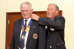 John places the Presidential Collar round Barry\'s neck