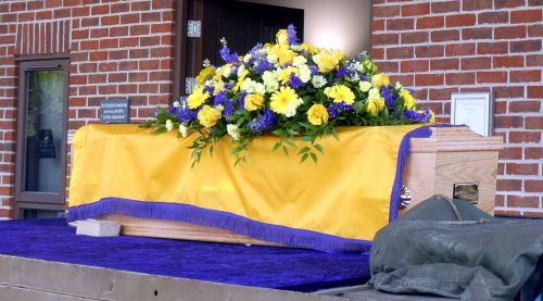 David's coffin with family flowers and draped in the Lions Flag.