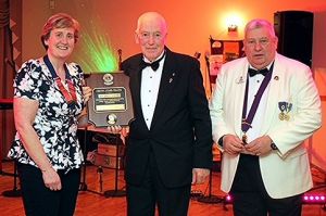 Roy Bridgewater (C) receives his Melvin Jones Fellowship from Lion President Jane (L) and District Governor David (R)