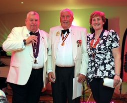 John Goodchild (C) receives his 35 year Service Award from DG David (L) and Lion President Jane (R)